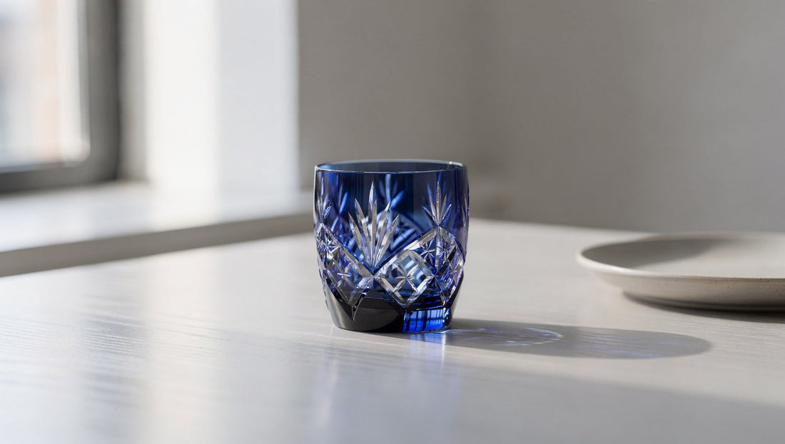 One cobalt cut glass on a contemporary table by a window.