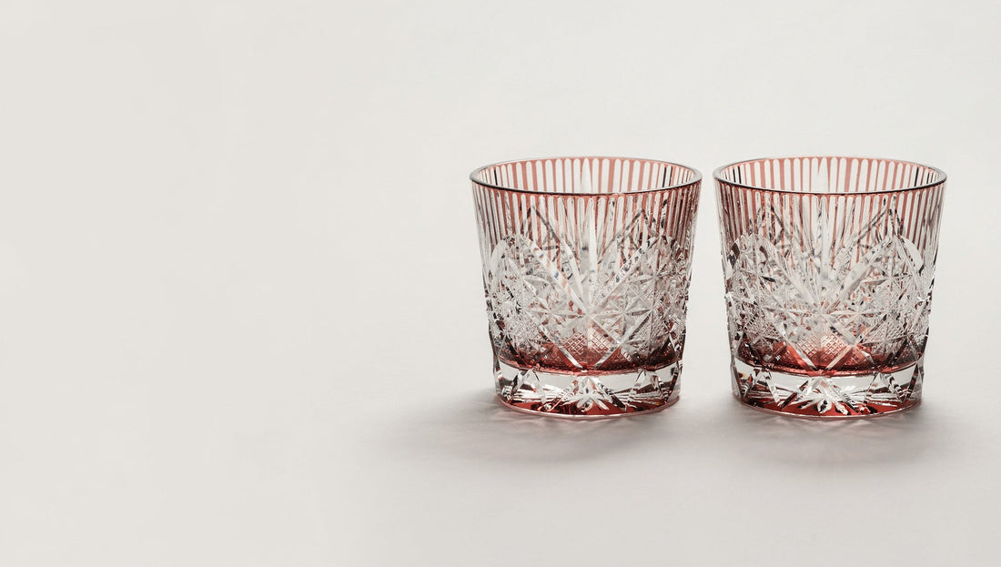 A quiet pair of empty Japanese cut-glass rocks glasses standing together on a pale ground, no ribbon.