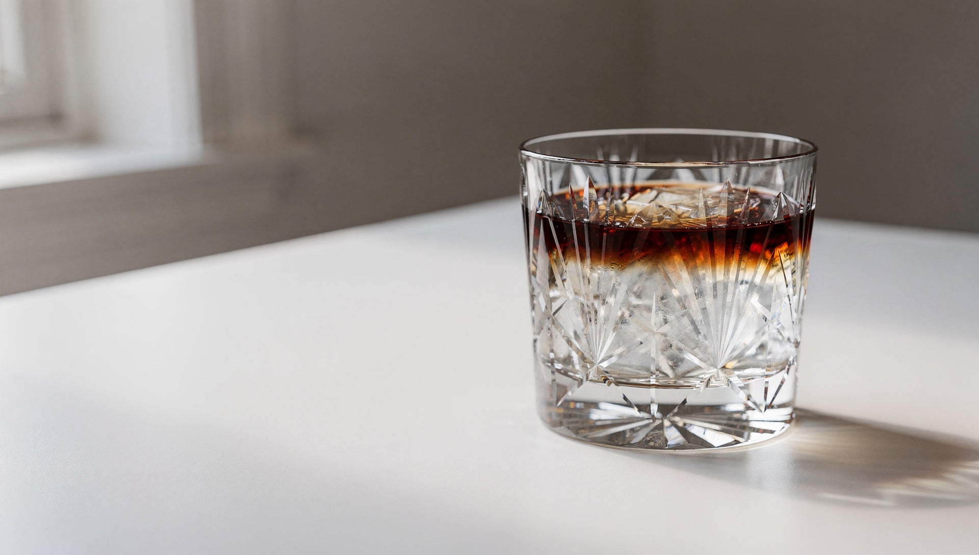 One Japanese cut glass on a new empty table by a window, pale daylight.