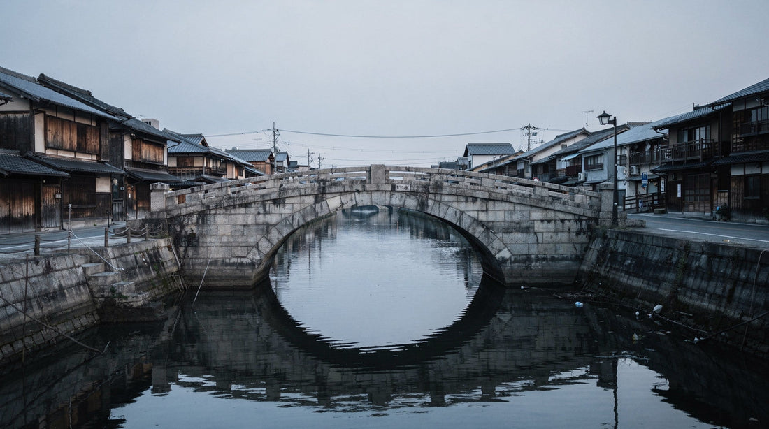 An empty Nihonbashi-like stone bridge and quiet water at dawn