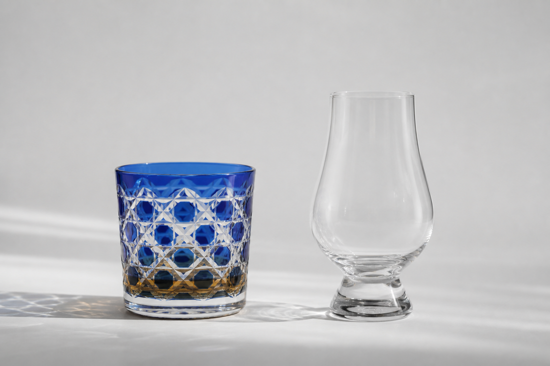 A cobalt Japanese cut-glass rocks glass beside a clear Glencairn tasting glass on pale ground