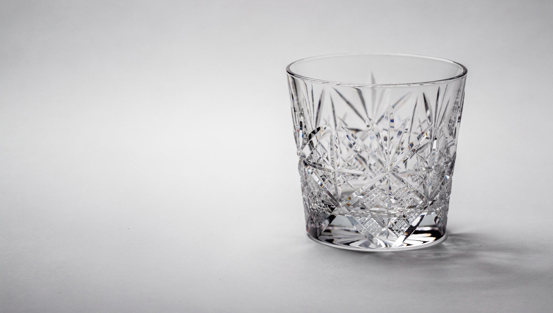 One Japanese cut-glass rocks glass on a pale table, three-quarter product view as if choosing it online.