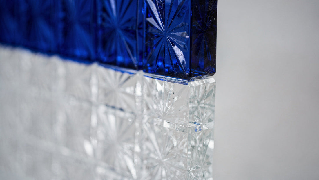 Macro of cobalt overlay Japanese cut glass where a cut meets clear glass, sharp colour line in focus.
