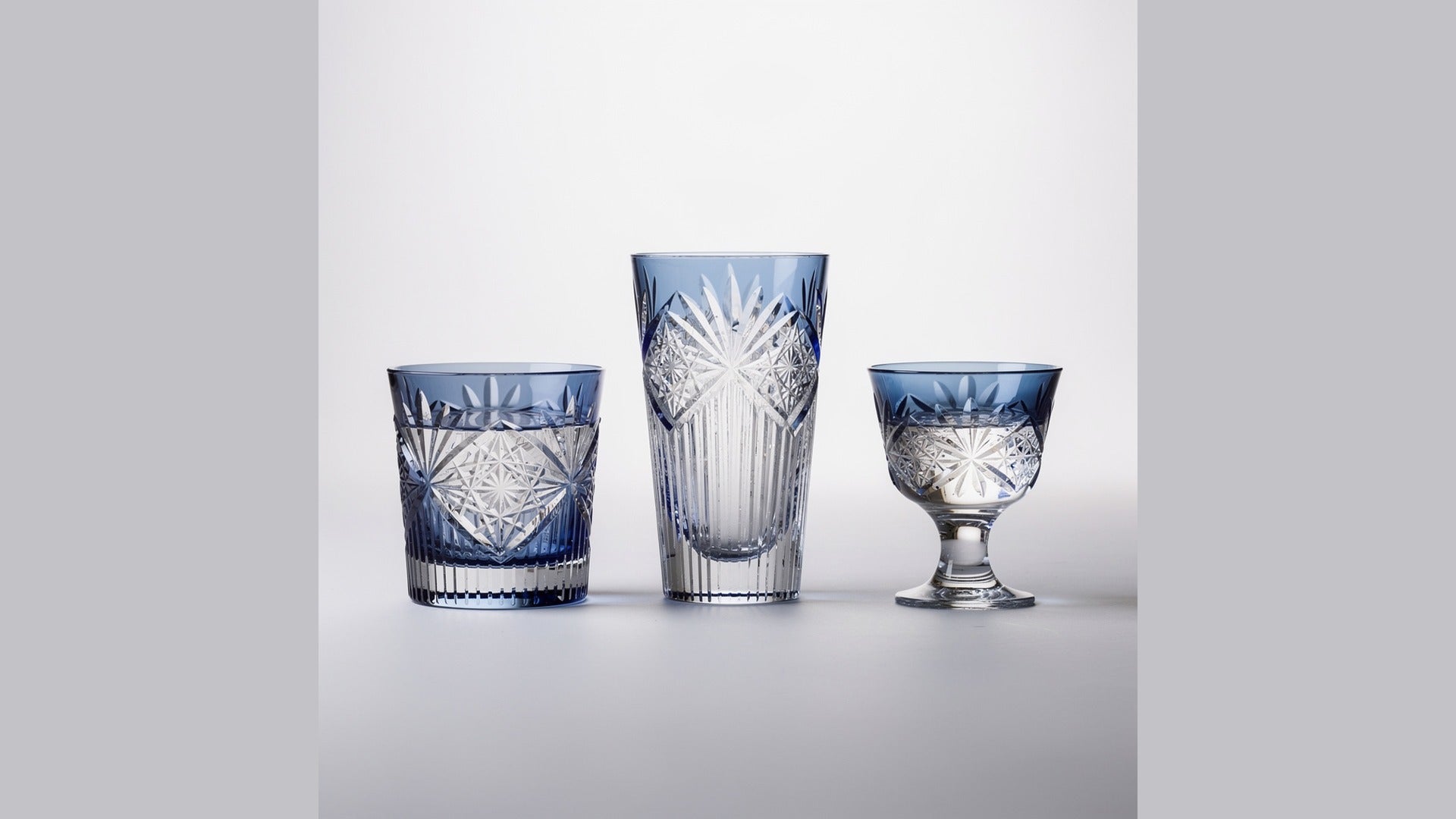Three Japanese cut glasses in a line: rocks, tumbler, and sake glass on a pale ground