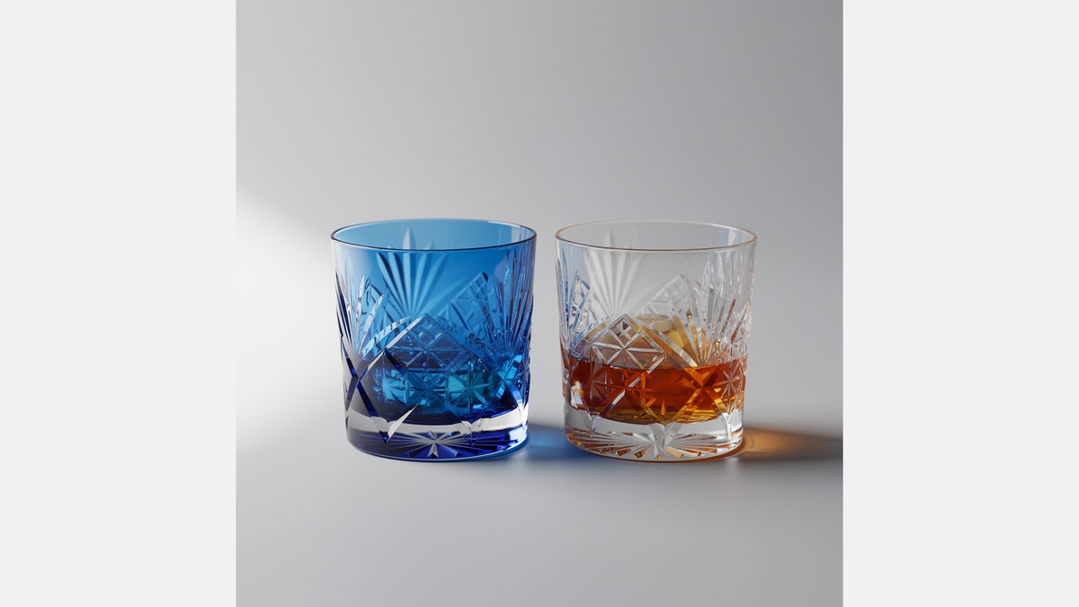 Two Japanese cut rocks glasses on pale ground, one cobalt and one clear with a short amber pour